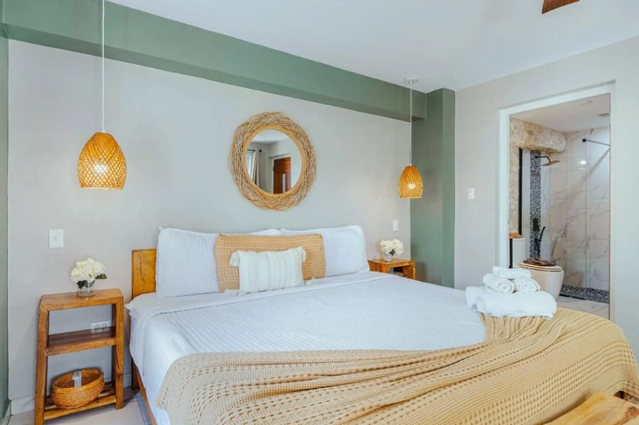 Bedroom with wicker bedside lamp and round mirror