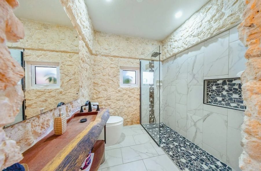Bathroom with stone wall and walk-in shower
