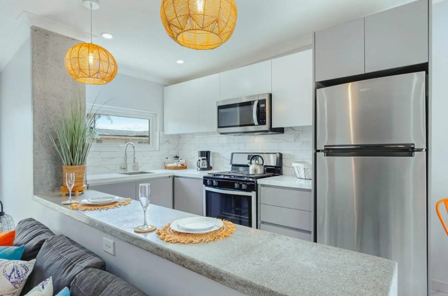 Kitchen with stainless steel fridge and breakfast bar