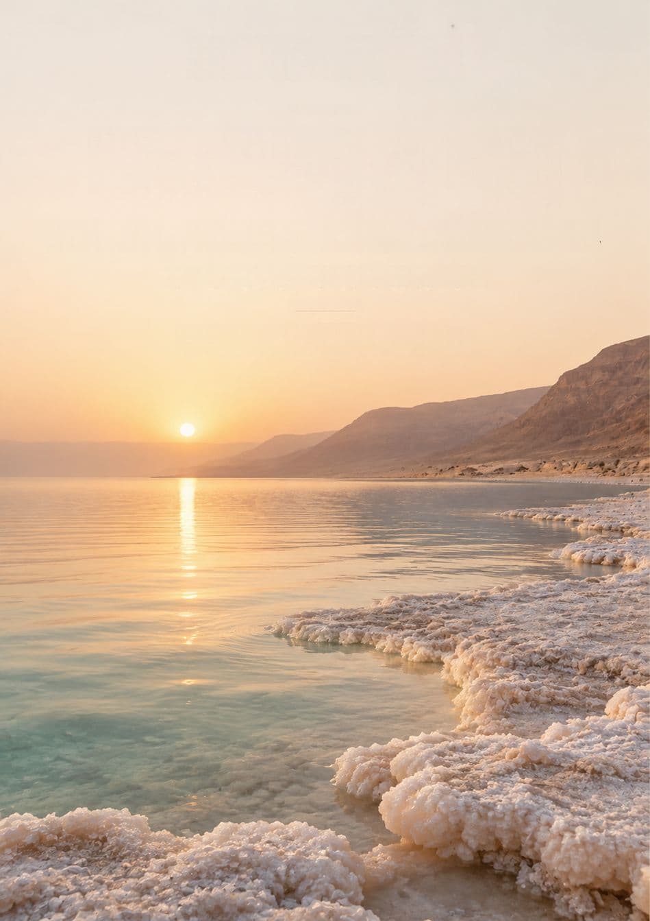 Sunset over the Dead Sea, with salt crystals along the shore