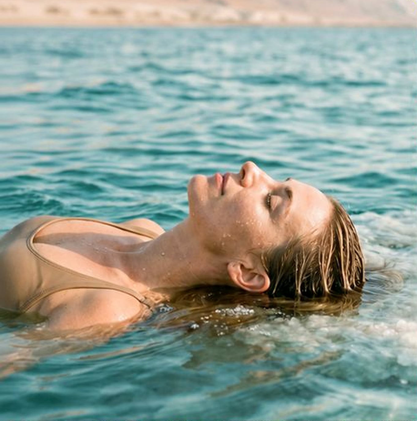 A woman floating on the calm water of the Dead Sea